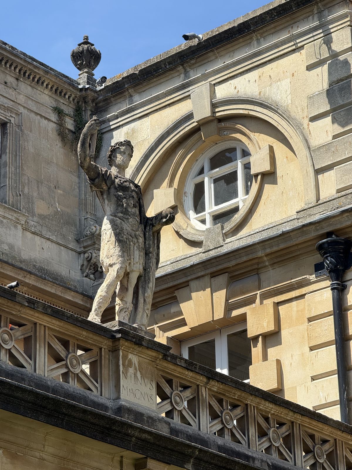 A weathered statue on the Victorian terrace overlooking the Great Bath at the Roman Baths